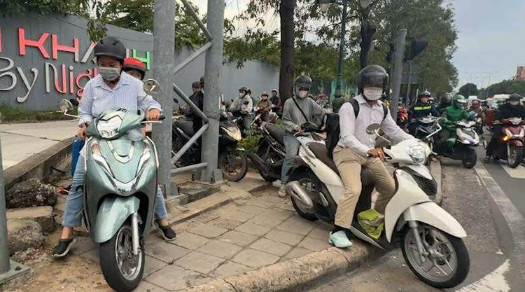 Hàng trăm phương tiện xe máy nối đuôi nhau chạy trên lề đường Mai Chí Thọ để cố thoát kẹt ở nút giao nói trên.