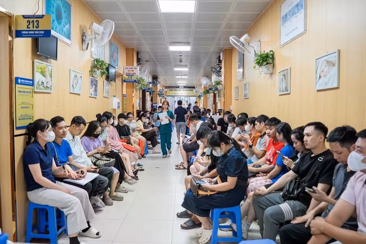 8h sáng, hành lang Trung tâm Hỗ trợ Sinh sản, Bệnh viện Bưu điện (Hà Nội), gần như không còn một khoảng trống. Tiếng gọi tên bệnh nhân liên tục vang lên giữa dòng người xếp hàng chờ đến lượt khám. Trong đám đông ấy là những cặp vợ chồng trẻ vừa kết hôn, những gia đình đã nhiều năm chạy chữa hiếm muộn để mong có con đầu lòng.