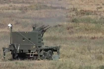 Một hệ thống phòng không tầm gần lắp trên rơ-moóc, trang bị pháo tự động đa nòng, đang triển khai trên thao trường trong một hoạt động huấn luyện/bắn thử nghiệm, thể hiện năng lực đối phó các mối đe dọa đường không tầm thấp như UAV.