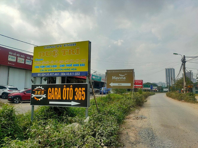 Biển báo chỉ dẫn vào các nhà xưởng, nhà kho, gara ô tô… dựng san sát trên dải phân cách giữa đường, che khuất tầm nhìn của người điều khiển phương tiện.