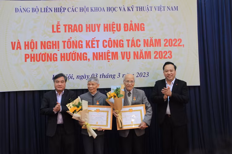 Phó Chủ tịch VUSTA Phạm Quang Thao và ông Đỗ Việt Hà - Phó Bí thư Đảng ủy Khối các cơ quan Trung ương trao Huy hiệu cho các đảng viên.