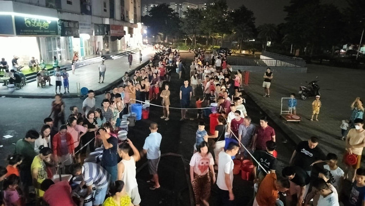 Tre nho xach xo chau theo nguoi lon xep hang cho nuoc o KDT Thanh Ha