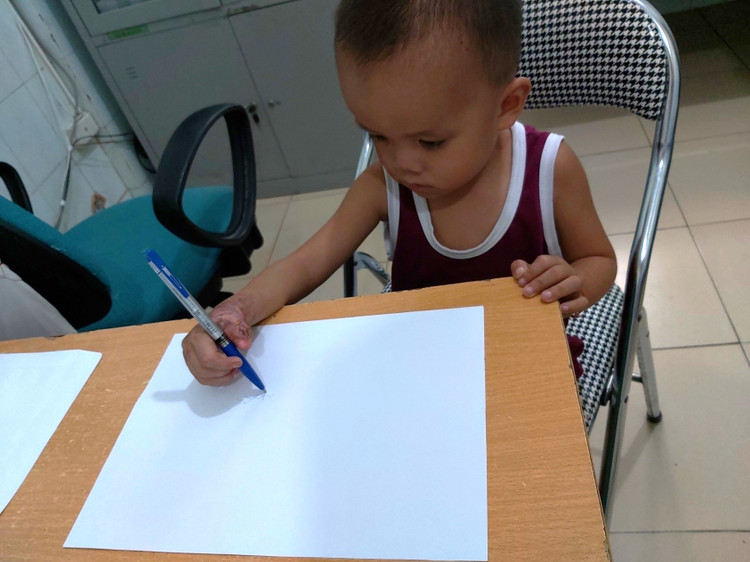 Tay bé đã có thể cầm bút viết - Ảnh BVCC