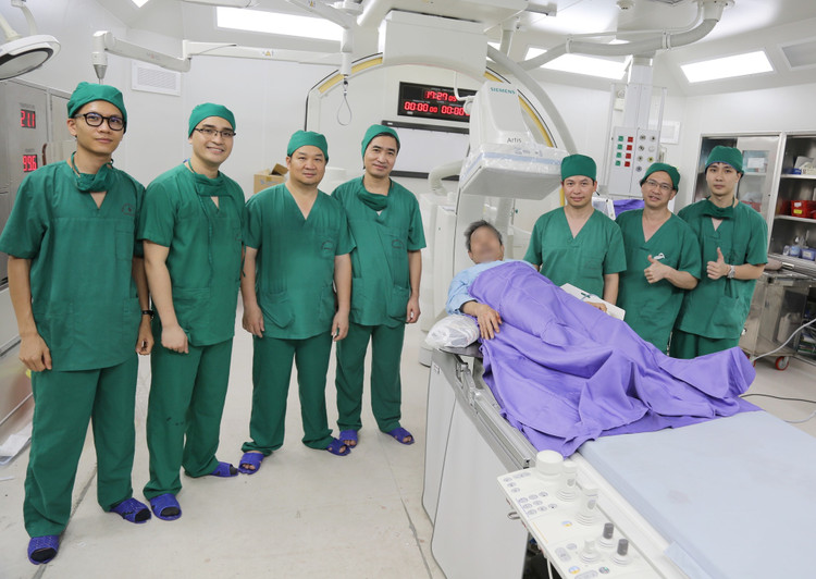 Bệnh nhân tỉnh táo chụp ảnh lưu niệm cùng kíp bác sĩ ngay sau can thiệp.