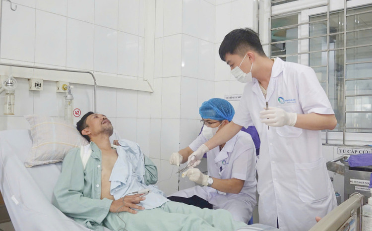 Bác sĩ CKII Hoàng Văn Quyết rút ống dẫn lưu khoang màng phổi cho người bệnh sau 1 tuần phẫu thuật. - Ảnh BVCC