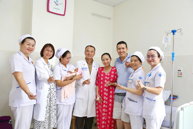 Đại diện Ban giám đốc – Bác sĩ Phẫu thuật và trưởng phòng Công tác xã hội đến tặng quà chúc mừng gia đình chị N đã trải qua một hành trình dài và vô cùng đặc biệt - Ảnh BVCC