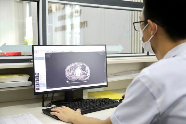 Bác sĩ xem phim chụp của bệnh nhân để lên phương án phẫu thuật - Ảnh BVCC