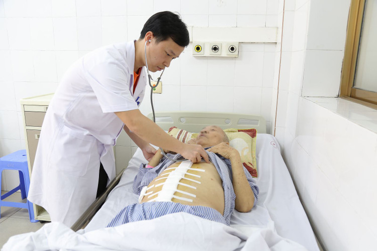 Bác sĩ khoa Ngoại kiểm tra lại vết mổ cho cụ ông 85 tuổi bị vỡ phình động mạch chủ bụng - Ảnh BVCC