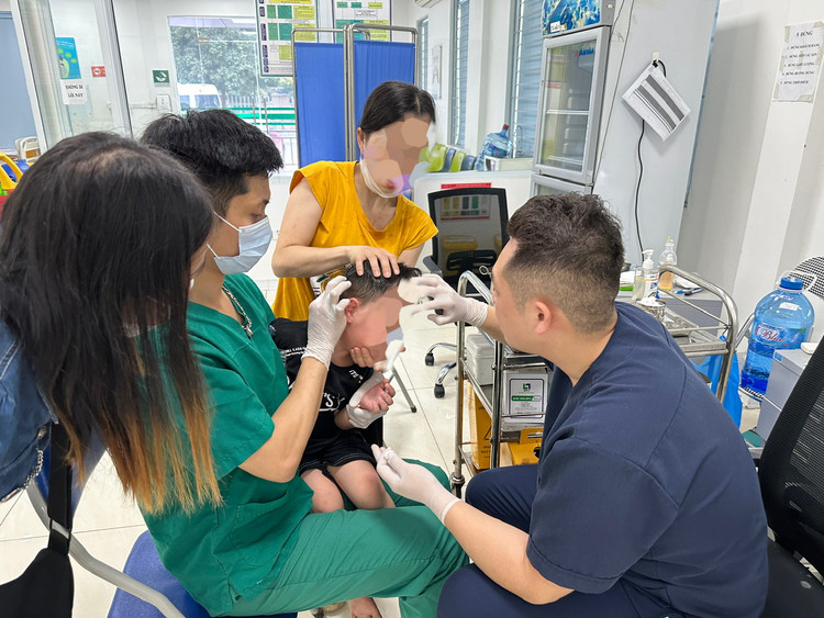 Một cháu bé bị chó nhà hàng xóm cắn đi tiêm phòng dại - Ảnh BVCC