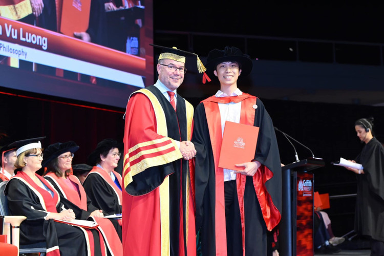 Vũ nhận bằng trong buổi lễ tốt nghiệp.