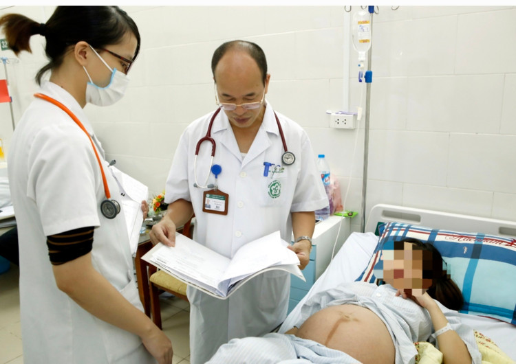 PGS.TS Đỗ Duy Cường thăm khám cho thai phụ bị viêm gan B đang được theo dõi, điều trị tại Trung tâm bệnh nhiệt đới - Ảnh BVCC