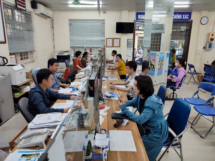 Giải quyết thủ tục cho người dân tại Bảo hiểm Xã hội quận Thanh Xuân - Ảnh: Báo Hà Nội Mới