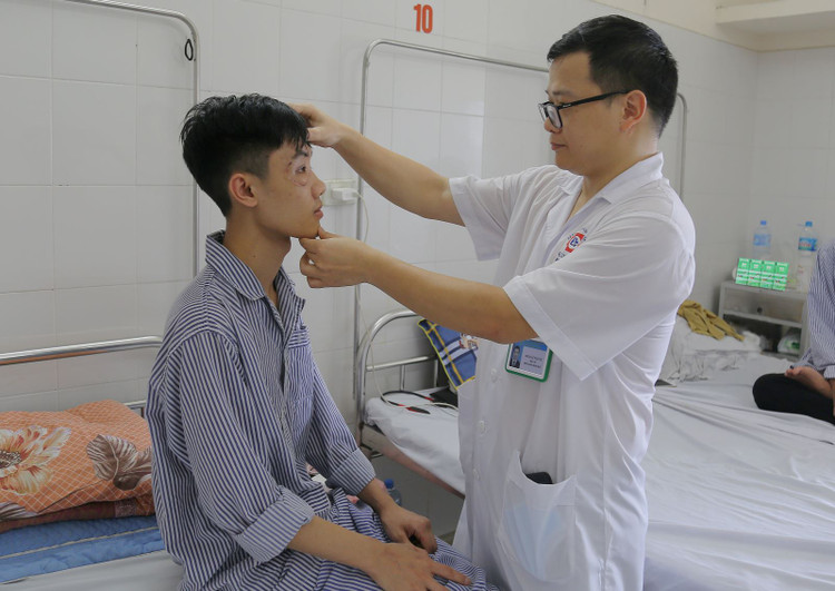 BS.CKI Lê Tuấn Tú thăm khám lại cho người bệnh được phẫu thuật tạo hình ổ mắt.