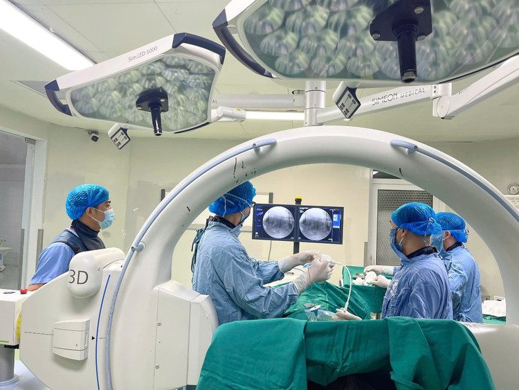 Hình ảnh các bác sĩ đang thực hiện can thiệp bơm cement - Ảnh: BVCC