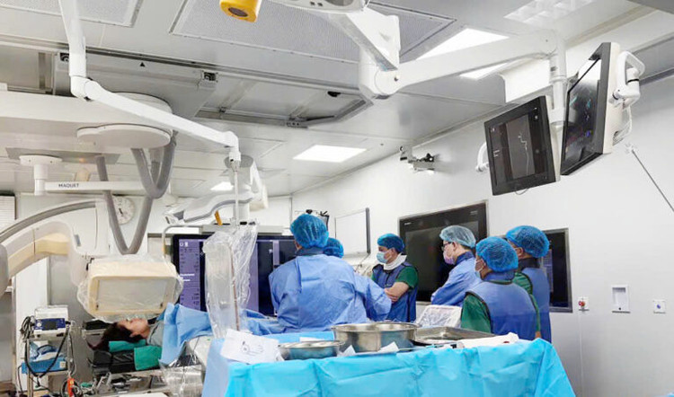 Ekip đang thực hiện đặt stent chuyển hướng dòng chảy qua túi phình - Ảnh BVCC