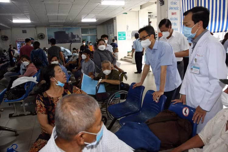 Người dân ngồi chờ để được nhận thuốc.