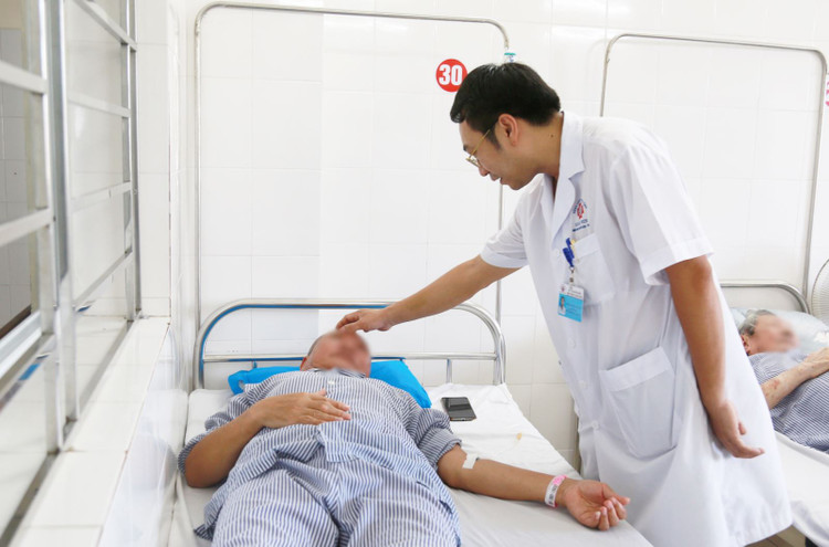 Bác sĩ Nguyễn Tiến Dũng thăm khám và động viên bệnh nhân trước mổ