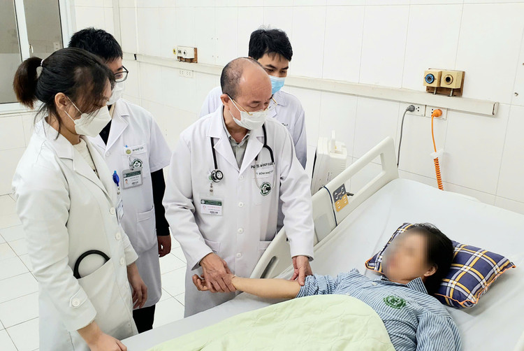 PGS.TS Đỗ Duy Cường - Giám đốc Trung tâm Bệnh Nhiệt đới và các bác sĩ thăm khám cho bệnh nhân - Ảnh BVCC