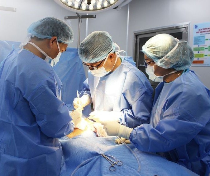 BS Hùng (giữa) phẫu thuật bóc u buồng trứng vỡ cho chị Hoa
