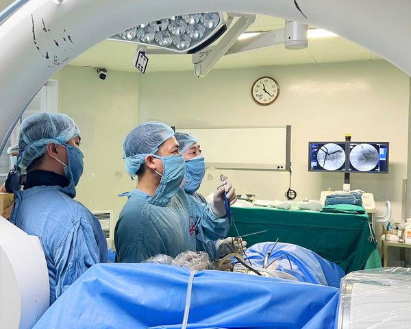 Ekip đang thực hiện phẫu thuật nội soi hai cổng giải chèn ép ống sống cho người bệnh - Ảnh BVCC