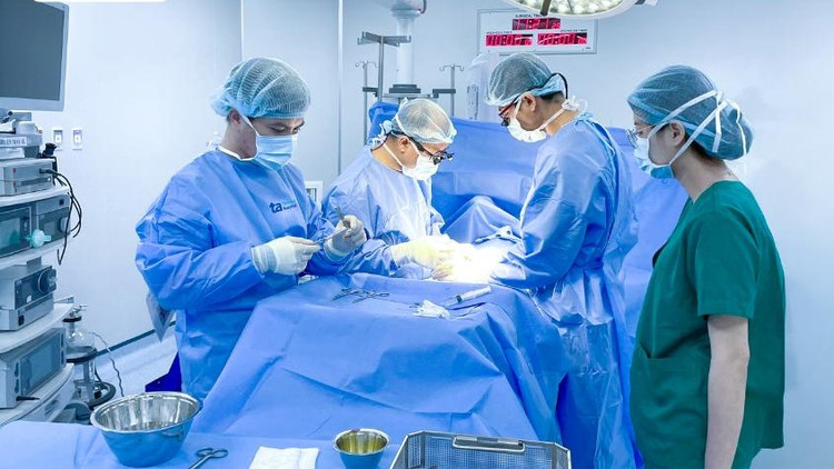 Bác sĩ Vũ (thứ hai từ phải sang) phẫu thuật bóc tách khối u cho bé Trân - Ảnh BVCC