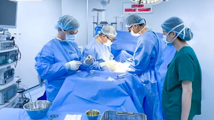 Bác sĩ Vũ (thứ hai từ phải sang) phẫu thuật bóc tách khối u cho bé Trân - Ảnh BVCC