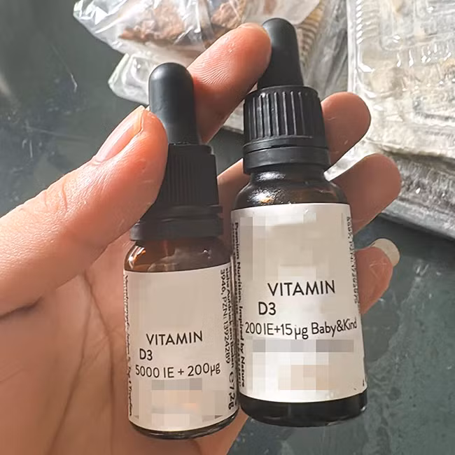 Lọ vitamin D 5000 IE +200 μg dành cho người lớn (bên trái) mà trẻ được cho uống nhầm (ảnh gia đình cung cấp)