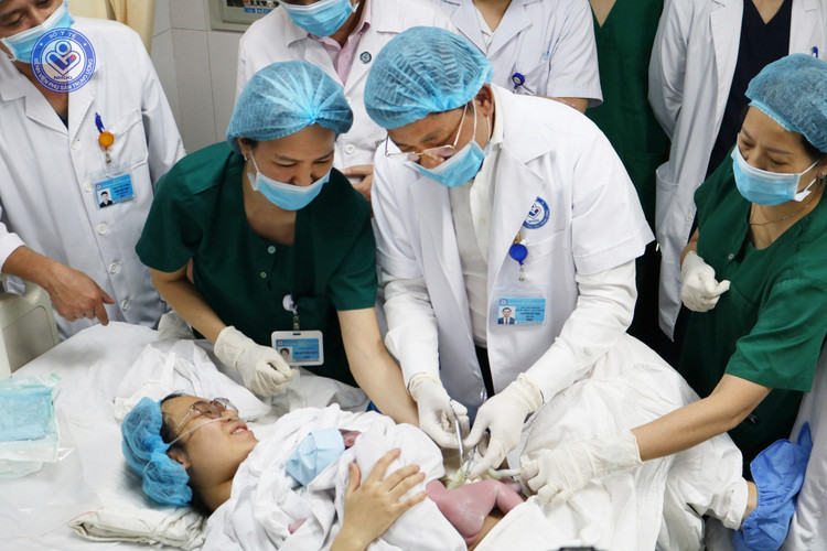 GS.TS Nguyễn Duy Ánh cắt dây rốn cho em bé sinh đầu tiên năm 2025 tại bệnh viện - Ảnh BVCC