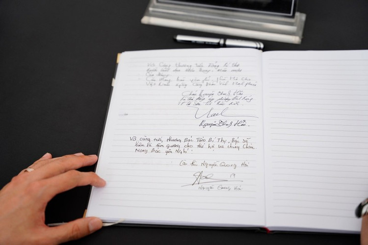 Cầu thủ Quang Hải viết lưu bút sổ tang. (Ảnh: Thiên Anh)