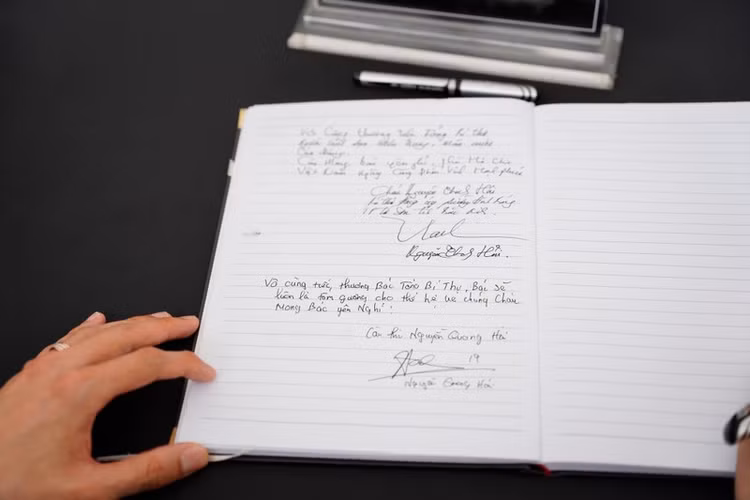 Cầu thủ Quang Hải viết lưu bút sổ tang. (Ảnh: Thiên Anh)