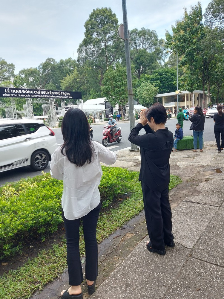 Nhiều người dân trong khi chờ vào viếng Tổng Bí thư Nguyễn Phú Trọng đã đứng phía ngoài vái vọng trước Hội trường Thống Nhất để tỏ lòng thành kính. Ảnh Hữu Thông