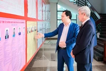 Ông Vũ Văn Tiến, Ủy viên Đoàn Chủ tịch, Trưởng Ban Tuyên giáo Cơ quan Ủy ban Trung ương MTTQ Việt Nam cùng cử tri xem thông tin người ứng cử