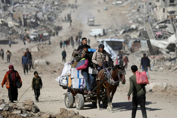 Palestinians make their way past the rubble of destroyed houses and buildings in Jabalia