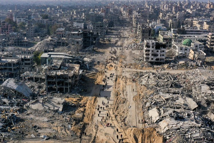 Displaced Palestinians walk past the rubble as they attempt to return to their homes, in the northern Gaza Strip