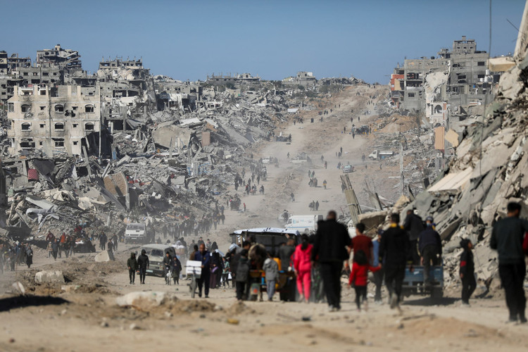 Palestinians make their way past the rubble of destroyed houses and buildings in Jabalia