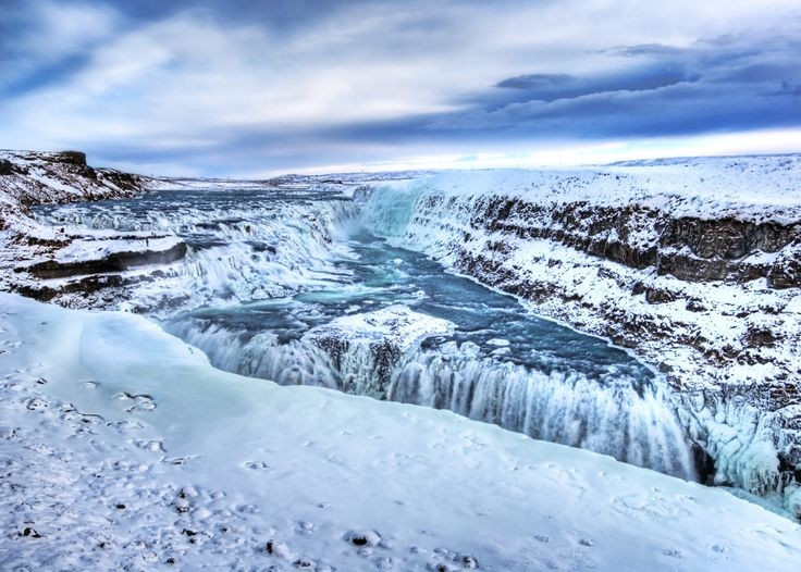 Cảnh sắc thay đổi theo mùa. Mùa hè, Gullfoss rực rỡ dưới ánh nắng. Đền mùa đông, thác đóng băng một phần, tạo nên khung cảnh huyền ảo như cổ tích. Ảnh: Pinterest.