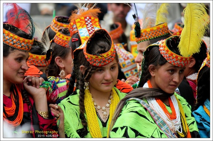 Trang phục và mũ đội đầu đặc trưng. Phụ nữ Kalasha nổi bật với váy đen dài thêu hoa văn rực rỡ và chiếc mũ đội đầu đính cườm, vỏ sò cùng đồng xu kim loại. Trang phục không chỉ mang tính thẩm mỹ mà còn thể hiện địa vị và truyền thống gia đình. Ảnh: Pinterest.