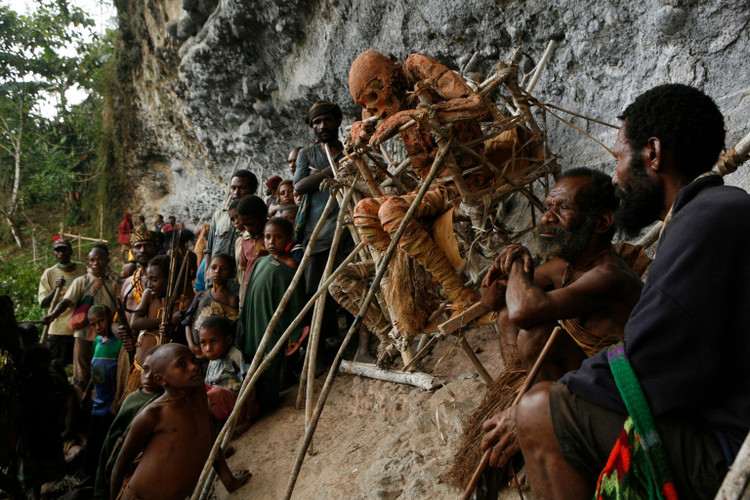 1. Tục hun khói xác chết: Bộ tộc Anga ở Papua New Guinea đặt thi thể người thân ngồi trên giàn gỗ và hun khói suốt 3 tháng để giữ nguyên hình hài và tránh linh hồn quấy nhiễu. Ảnh: NatGeo.