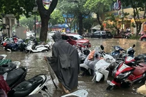 Xe để trên vỉa hè phố Trần Hưng Đạo cũng bị ngập quá nửa bánh. Ảnh: Thanh Thúy.