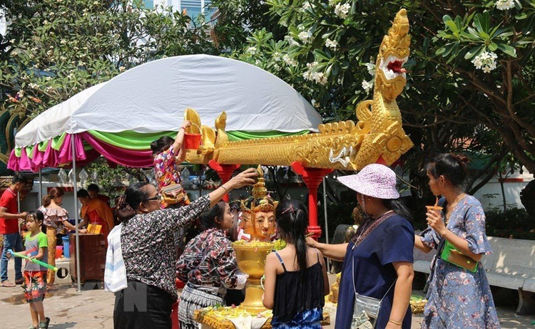 Mọi người thực hiện nghi lễ tắm Phật tại chùa. Ảnh TTXVN