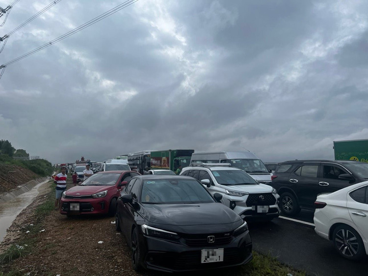 Nhiều phương tiện không dám lưu thông. Một số xe tải chạy qua bị nước nâng lên, trôi dạt vào lề, ngập nửa thân xe, kẹt ở hiện trường. Ảnh: Lê Xuân Thọ