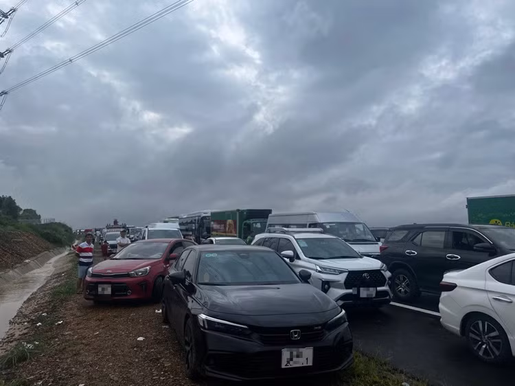 Nhiều phương tiện không dám lưu thông. Một số xe tải chạy qua bị nước nâng lên, trôi dạt vào lề, ngập nửa thân xe, kẹt ở hiện trường. Ảnh: Lê Xuân Thọ