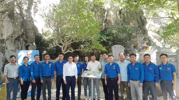 Các đại biểu bàn giao công trình thanh niên số hóa di tích lịch sử Hang Hỏa Tiễn. Ảnh: Cổng thông tin điện tử Thị xã Hoàng Mai.