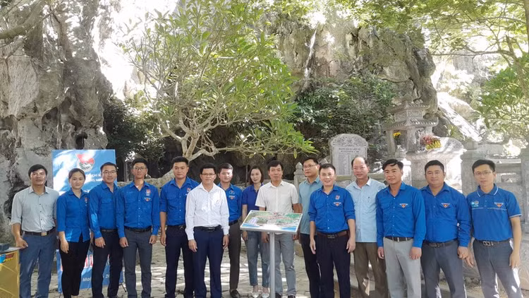 Các đại biểu bàn giao công trình thanh niên số hóa di tích lịch sử Hang Hỏa Tiễn. Ảnh: Cổng thông tin điện tử Thị xã Hoàng Mai.