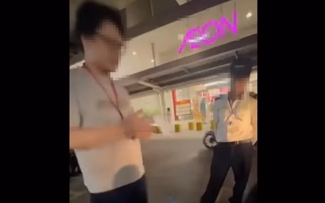 Người đàn ông (bên trái hình) giới thiệu là nhân viên an ninh của Aeon Long Biên tố cáo chị N. ăn cắp đồ trong siêu thị. Ảnh cắt từ clip.