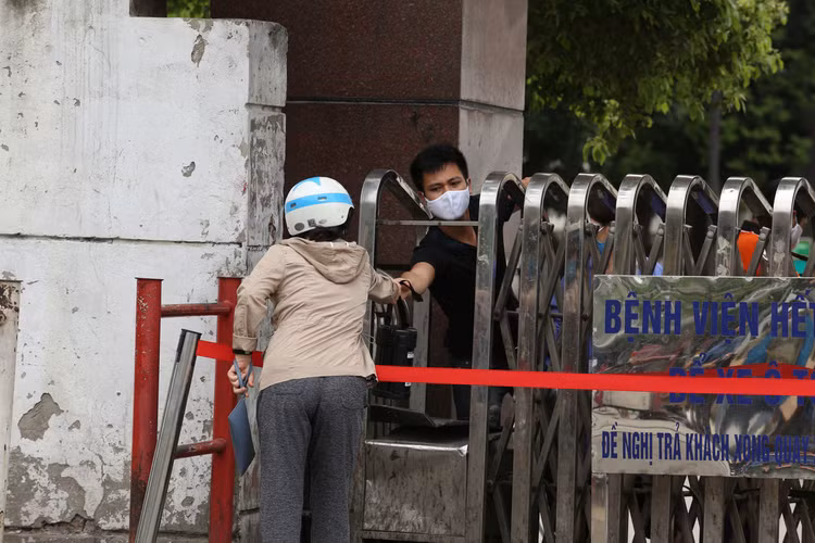 Bị từ chối tiếp tế, cố đưa đồ qua khe cổng bệnh viện Bạch Mai