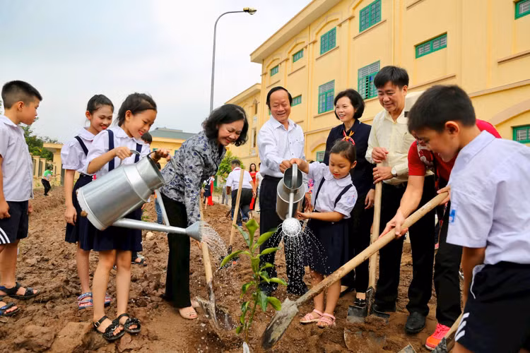 Bà Trương Thị Mai, Ủy viên Bộ Chính trị, Bí thư T.Ư Đảng Trưởng ban Ban Dân vận T.Ư cùng các em học sinh trồng cây và chụp hình lưu niệm bên những cây xanh vừa trồng trong chương trình “Quỹ 1 triệu cây xanh cho Việt Nam”.