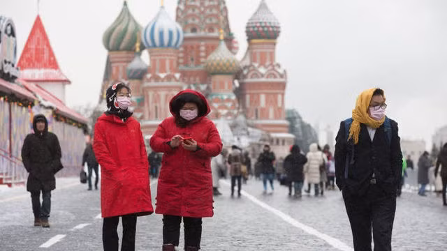 Khách du lịch đeo khẩu trang bên ngoài Điện Kremlin ở Moscow