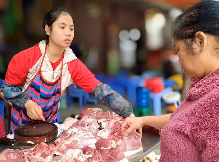 Người dân chọn mua thịt heo tại một chợ ở Hà Nội. Ảnh: Anh Minh