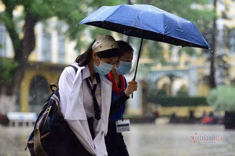Thí sinh đến trường thi môn Toán trong cơn mưa